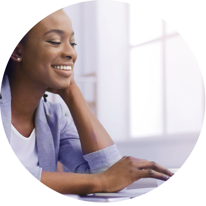 A smiling woman in a light blue blazer over a white top, resting her head on her hand and looking to the side, framed within a circular border on a white background.
